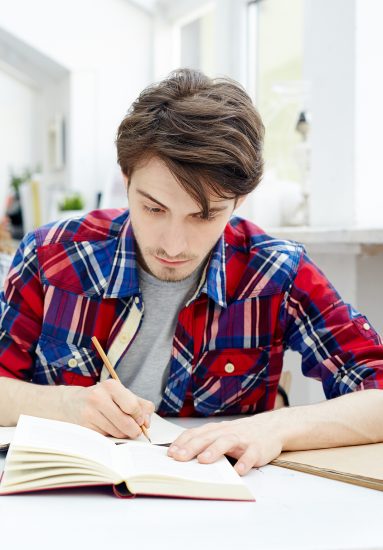 Clever student making notes at lesson